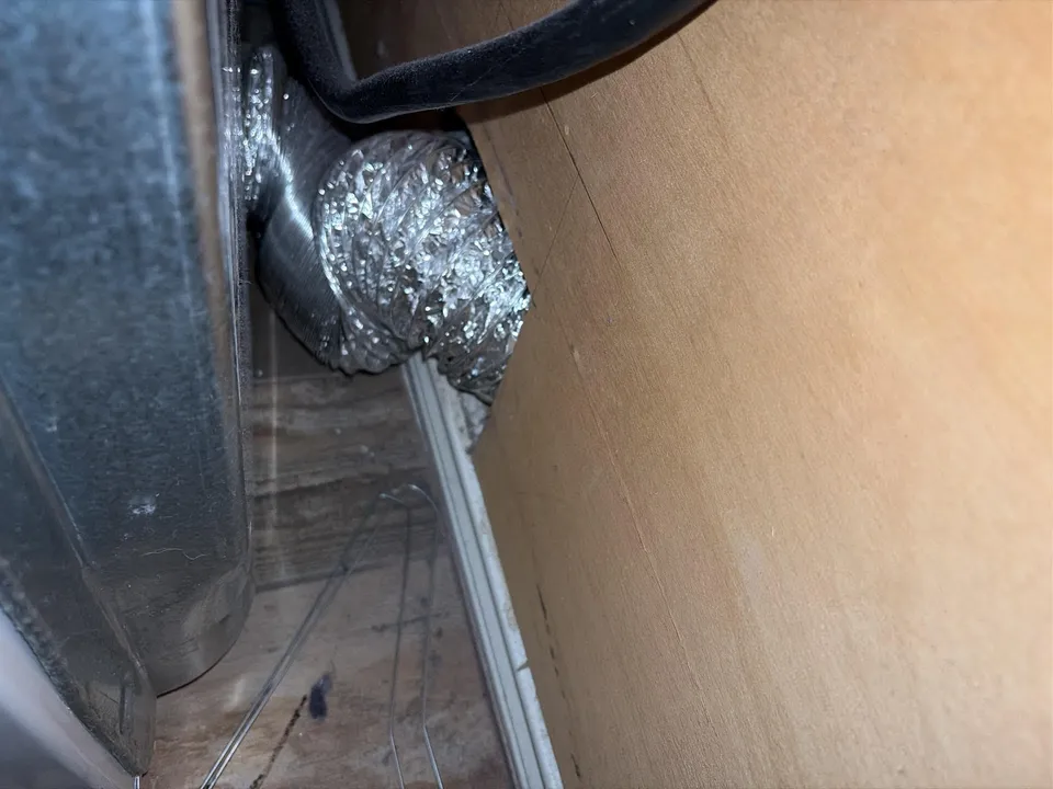 Flexible dryer vent duct behind a laundry appliance