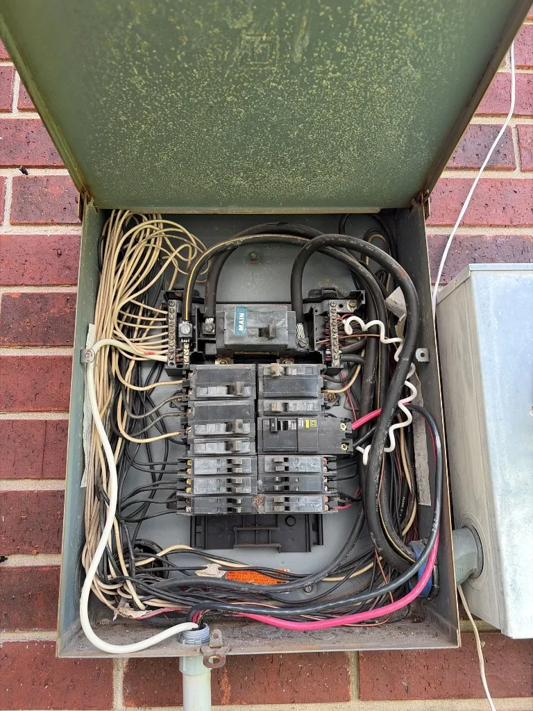 Open electrical service panel with breakers and wiring