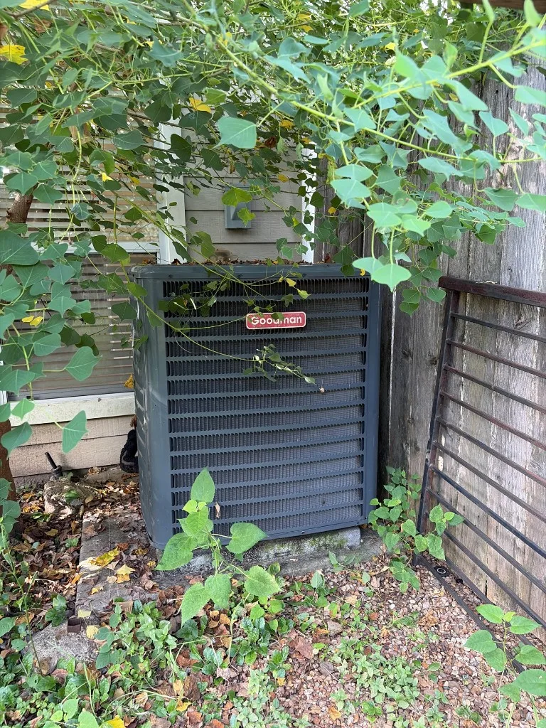 Outdoor air conditioning condenser unit beside a home