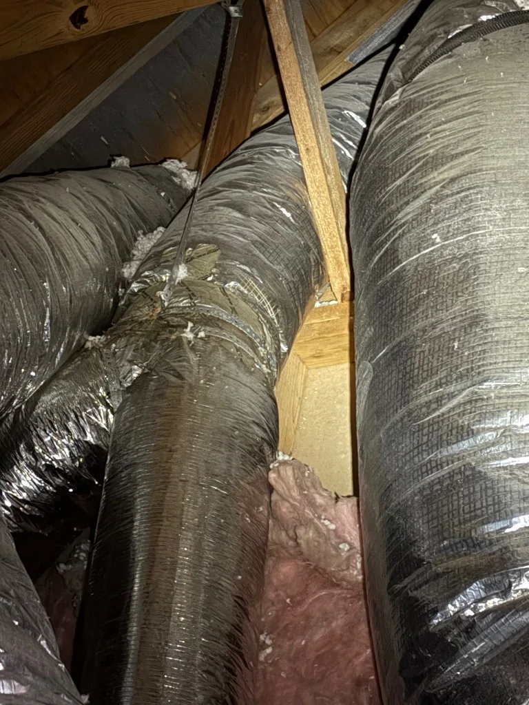 Flexible HVAC ductwork routed through attic framing