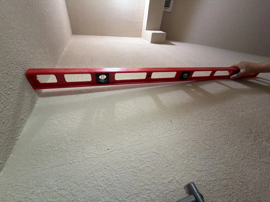Level used to check a cracked interior wall for movement
